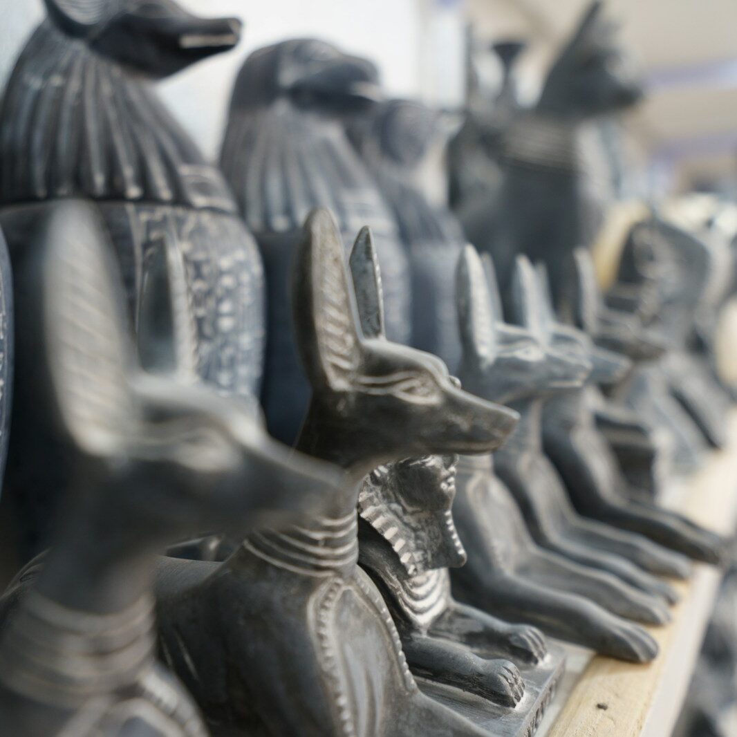 a row of black statues sitting on top of a shelf